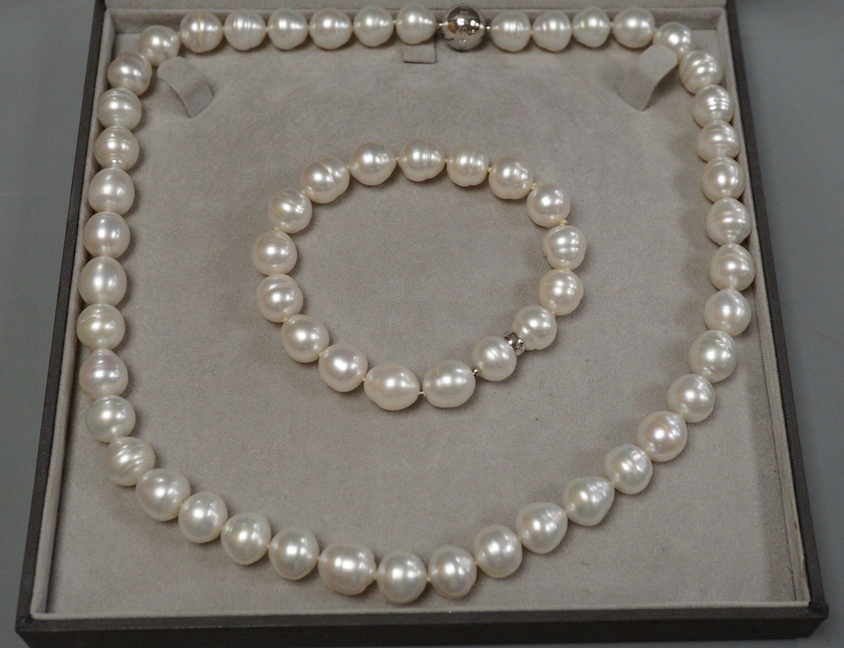 A cased modern Australian Kailis single strand South Sea pearl necklace, 53cm and matching bracelet, 19cm, both with diamond set white metal (tests as 18ct) clasps, retailed by Musson.